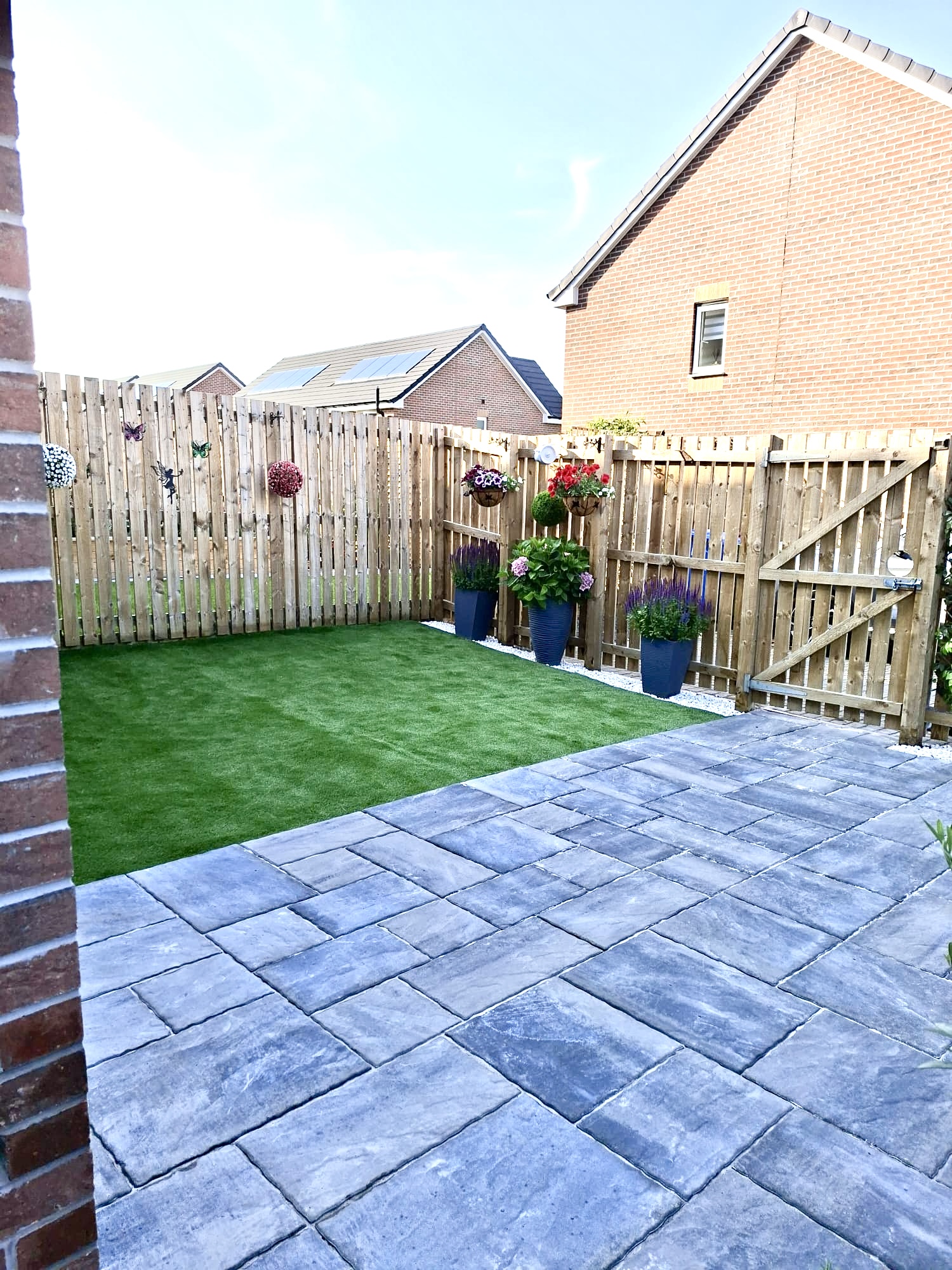 Slabbed patio with artificial lawn, planters and new fencing
